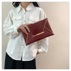 Elegante pochette a busta bordeaux con trama coccodrillo e bordo in metallo dorato