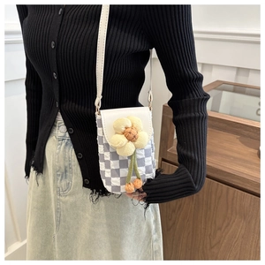 Detail of blue checkerboard phone bag with 3D yellow flower charm and white strap