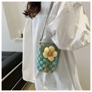 Detail of mint green checkered phone bag with a yellow 3D flower and green strap