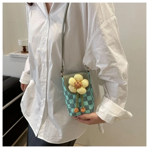 Detail of mint green checkered crossbody phone bag with a 3D yellow fabric flower