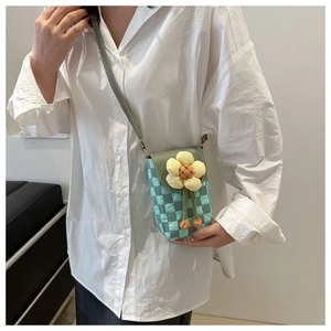 Detail of mint green checkered phone bag with 3D yellow floral ornament and shoulder strap