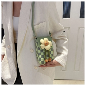 Detail of green checkerboard mini phone bag with a large white 3D fabric flower