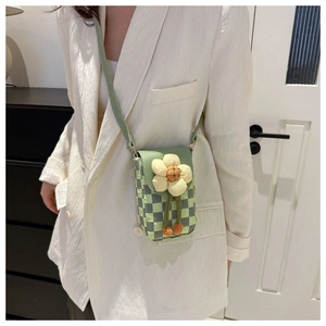 Detailed view of checkered mini crossbody phone bag with floral applique on white blazer