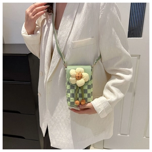 Detail of green checkerboard crossbody phone bag with yellow flower and thin strap