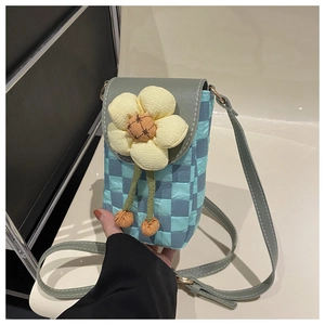 Close-up of sky blue checkerboard crossbody bag featuring a large yellow fabric flower