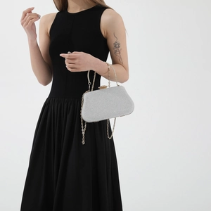 Elegant silver glitter evening clutch bag with golden arched handle and chain strap for women