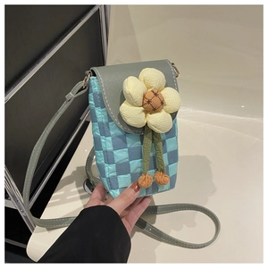 Detail of quilted checkered crossbody bag with a decorative 3D yellow fabric flower