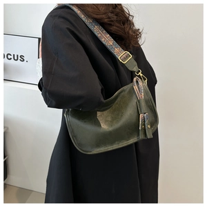 Détail du sac demi-lune vert foncé avec cuir vintage et sangle jacquard ethnique
