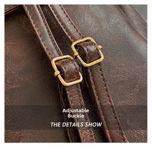 Detail of adjustable gold buckle and dark brown textured leather shoulder strap