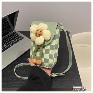 Detail of green checkerboard quilted phone bag with large 3D fabric flower decor