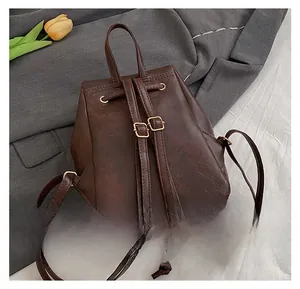 Rear view of vintage dark brown faux leather backpack with adjustable straps and gold buckles