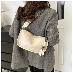 Détail du sac crème avec bandoulière en jacquard ethnique porté par un mannequin