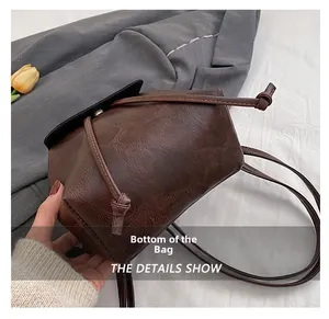 Detailed macro view of the dark brown leather backpack base with precise stitching