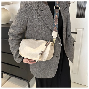 Détail du sac bandoulière avec bandoulière tissée ethnique et pompon sur le côté