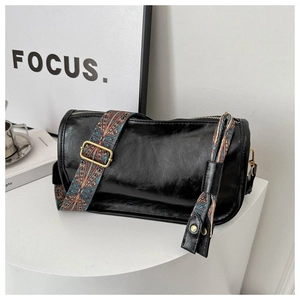 Détail du sac cylindre en cuir ciré vintage avec bandoulière ethnique géométrique