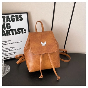 Detail of brown PU leather mini backpack featuring white butterfly and drawstring closure