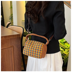 Model wearing a retro houndstooth and corduroy crossbody bag in a cozy cafe setting