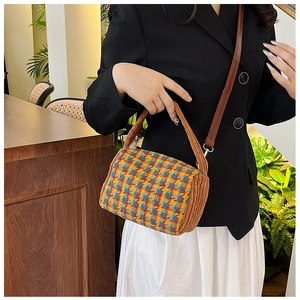 Detail of colorful plaid barrel bag with corduroy trim and elegant gold hardware