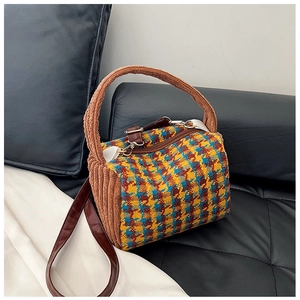 Detail of retro houndstooth handbag with brown plush handles and gold metal zipper