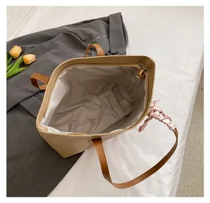 Top view of spacious tote bag interior featuring zip closure and white fabric lining