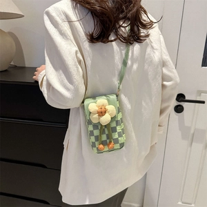 Checkerboard crossbody phone bag with 3D flower decoration worn by a model