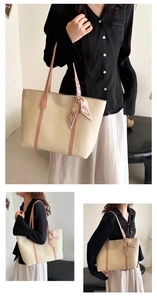 Detail of off-white leather tote bag with pink handles and stylish H-pattern silk scarf