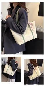 Detail of cream leather tote bag with avocado green straps and pink silk scarf detail
