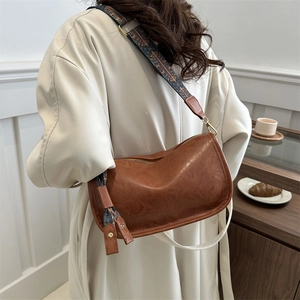 Sac bandoulière vintage en cuir marron avec large sangle ethnique et forme en demi-lune