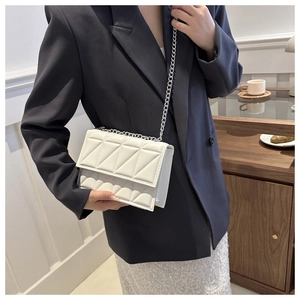 Chic beige quilted crossbody bag with silver chain strap shown on model's shoulder