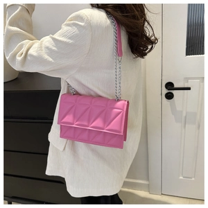 Pink quilted crossbody bag featuring a silver chain strap and geometric stitching