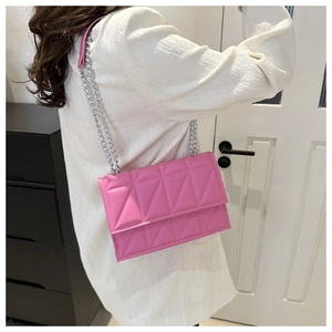 Detail of pink geometric quilted crossbody bag with stylish silver metal chain strap