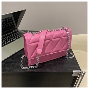 Detail of light pink PU leather bag featuring triangular geometric quilting and silver chain