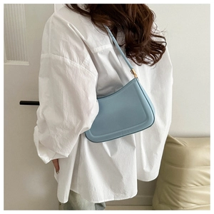 Vue latérale d'un sac porté épaule en similicuir bleu clair porté par un mannequin