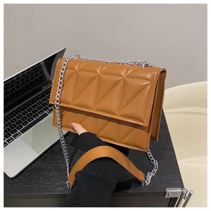 Detailed view of caramel brown quilted shoulder bag with silver chain and geometric pattern