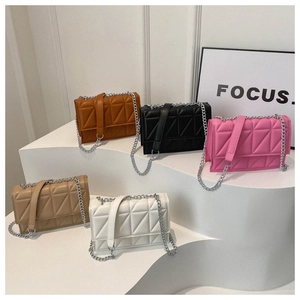 Collection of quilted crossbody bags in five colors on white tiered display stands