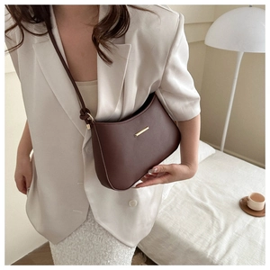 Detailed macro view of dark brown leather texture and golden metal buckle on the crossbody bag