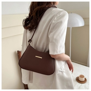 Detail of minimalist dark brown crescent shoulder bag with golden metallic buckle