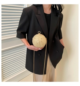 Exquisite gold hollow-out spherical evening bag with metal chain strap detail on model