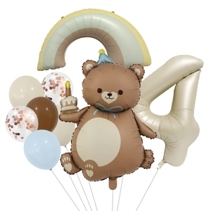 Detail of bear cake and rainbow foil balloons with number 4 for birthday party decor