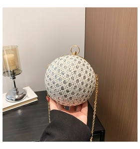 Detailed close-up of spherical evening bag with silver sequins and gold ring handle