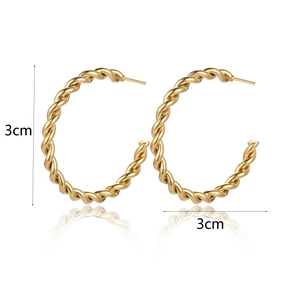 Detail of 3cm gold titanium steel twisted hoop earrings with pleated texture and C-shape