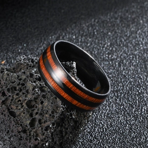 Detailed close-up of a men's black stainless steel ring with dual red wood grain inlays