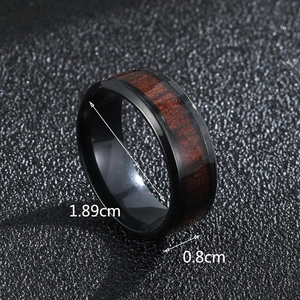 Macro detail of men's black stainless steel ring with wood inlay, width 8mm, inner 1.89cm