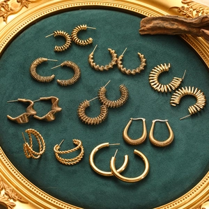 Set di orecchini geometrici in acciaio inossidabile dorato su velluto verde scuro