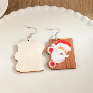 Handcrafted wooden Christmas earrings featuring Santa Claus on a white ceramic plate