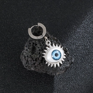 Vintage stainless steel evil eye hoop earring with blue iris on volcanic rock