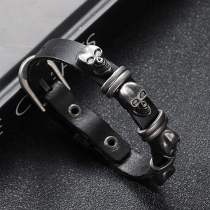 Close-up of punk leather bracelet showing vintage silver skulls and buckle detail