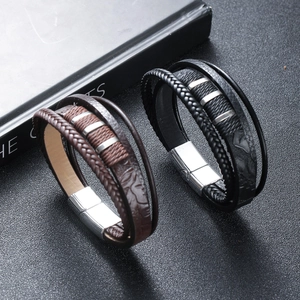 Detail of multi-layer leather bracelets with woven straps and silver magnetic metal clasps