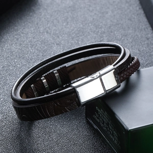 Detail of multi-layer leather bracelet with silver magnetic clasp and woven texture
