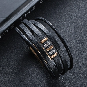 Close-up of multilayer black leather bracelet with gold and silver metal rings
